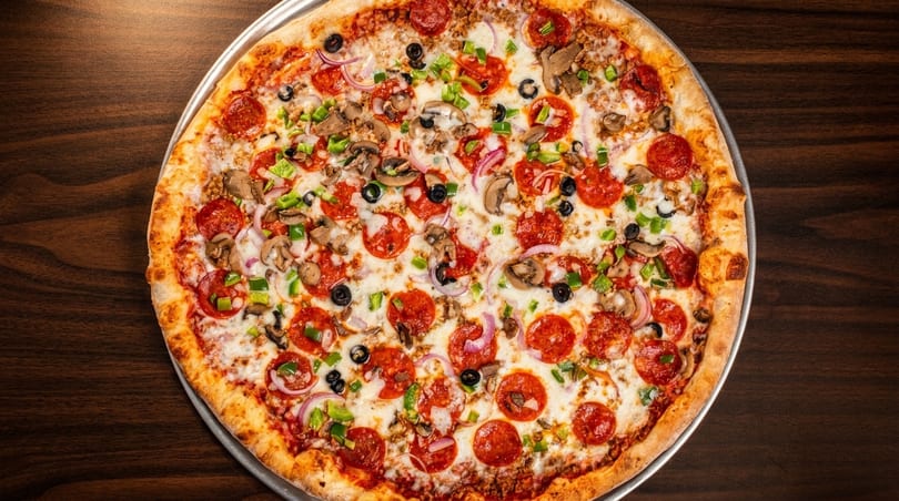 A large, fully loaded pizza with pepperoni, mushrooms, olives, onions, and green peppers.